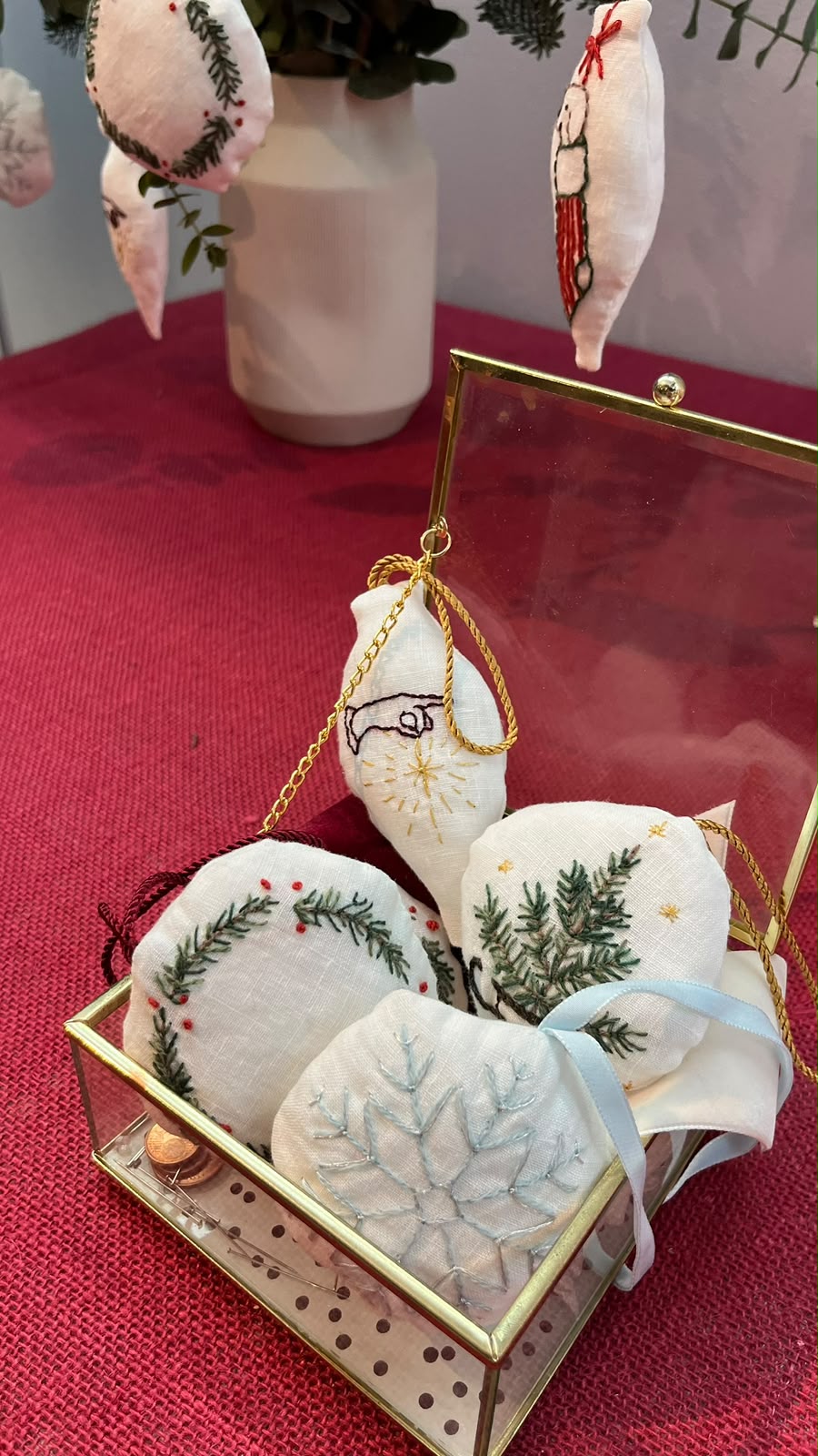 Detalle de adornos navideños bordados en una caja de cristal